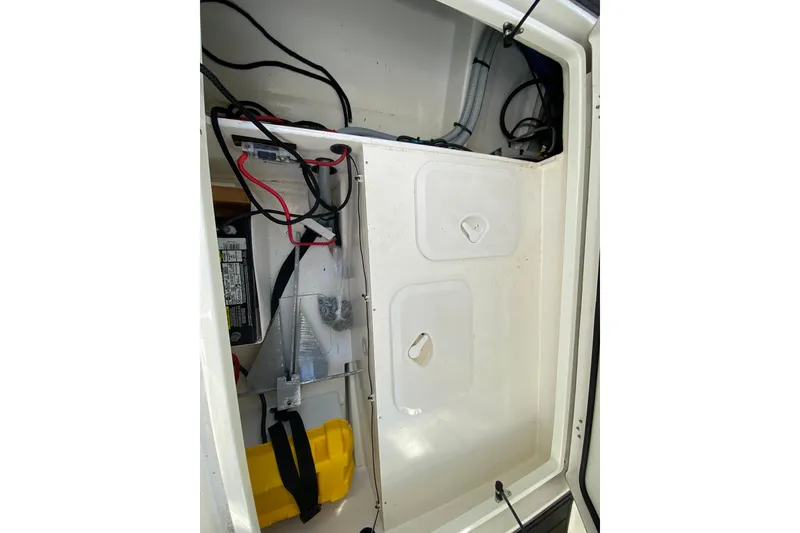 Slide: The Image of Interior view of 2022 Beneteau Antares 8 boat compartment with wiring and battery. - 49
