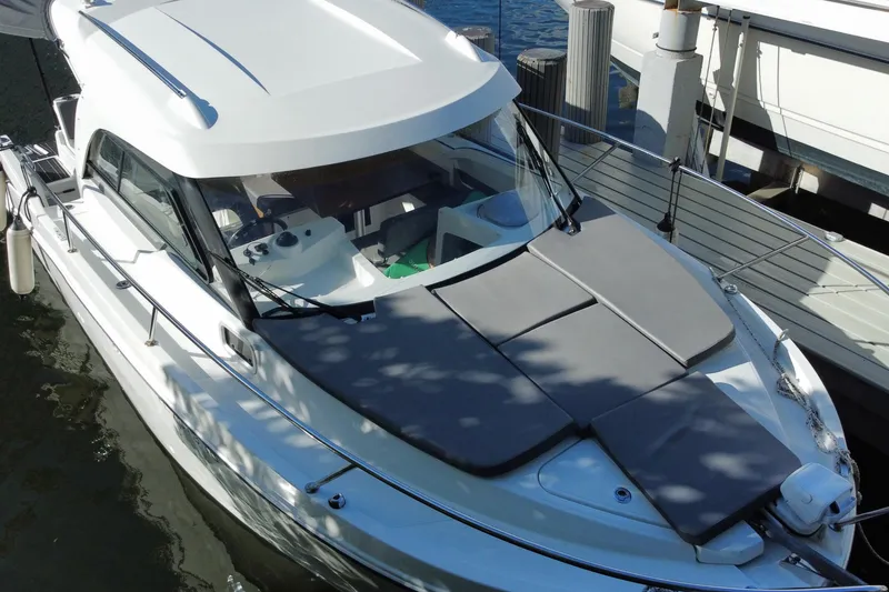 Slide: The Image of 2022 Beneteau Antares 8 docked near urban buildings and lush greenery. - 5