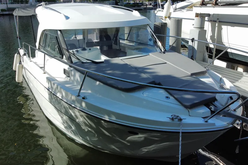 Slide: The Image of 2022 Beneteau Antares 8 boat docked on calm water, side view. - 6