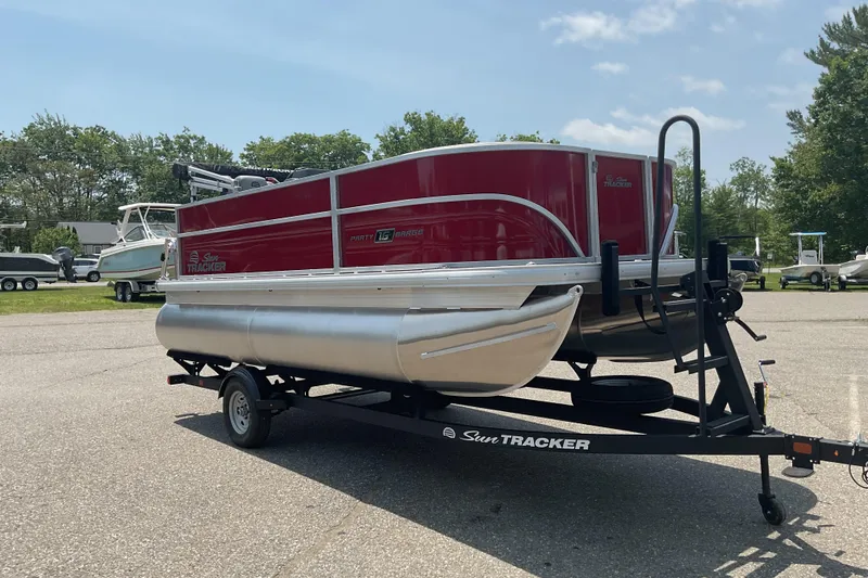 The Image of 2026 Sun Tracker Party Barge 16 DLX pontoon boat on trailer in sunny outdoor setting. - 0