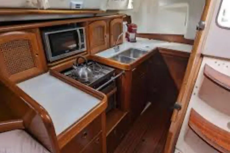 Slide: The Image of Interior of 2001 Beneteau Oceanis 411 yacht with white leather seating and wooden finish. - 9