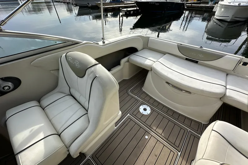 Slide: The Image of 2007 Sea Ray 225 Weekender boat interior with white seating and wood flooring. - 14