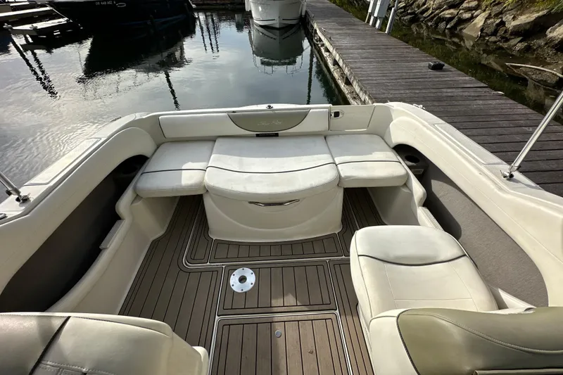 Slide: The Image of 2007 Sea Ray 225 Weekender boat interior with cushioned seating and wooden deck. - 15