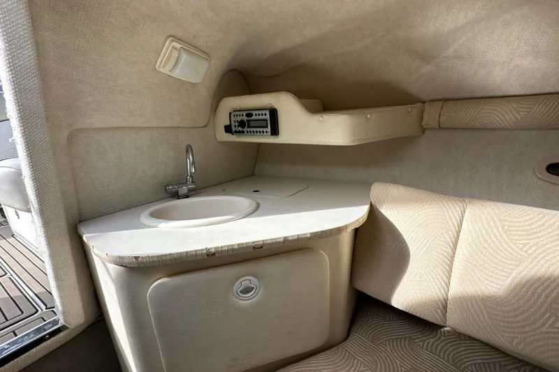 Slide: The Image of 2007 Sea Ray 225 Weekender cabin interior with sink and seating area. - 21