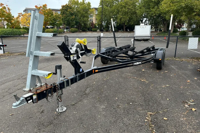 Slide: The Image of Boat trailer for 2007 Sea Ray 225 Weekender, parked in a lot with trees in background. - 27