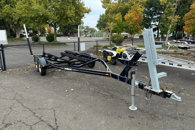 Slide: The Image of Boat trailer for 2007 Sea Ray 225 Weekender, parked in a lot with trees. - 29