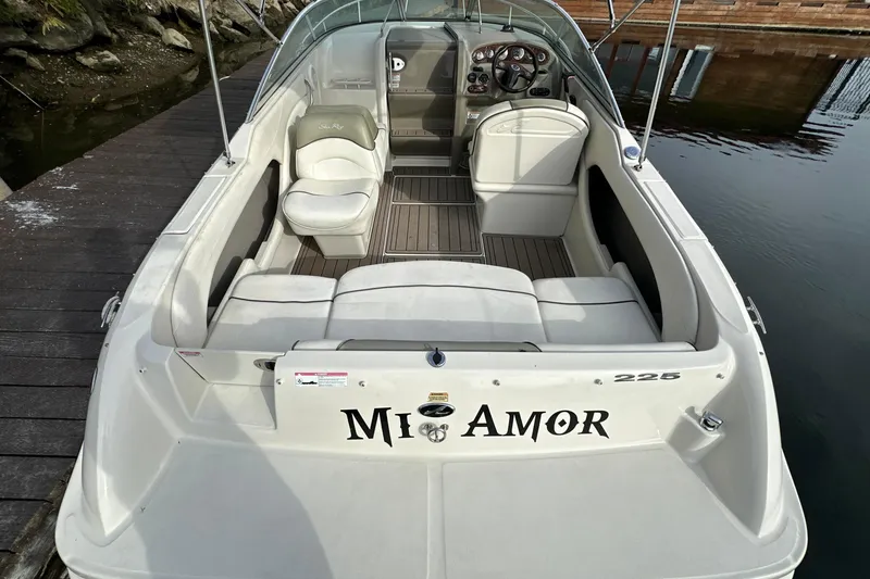 Slide: The Image of 2007 Sea Ray 225 Weekender boat docked, featuring spacious seating and sleek design. - 7