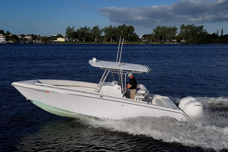 The Image of 2005 Jupiter 27 boat cruising on a calm lake with a person steering. - 0
