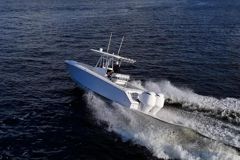 Slide: The Image of A 2005 Jupiter 27 boat cruising on open water, creating a dynamic wake. - 13