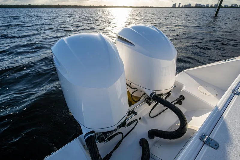 Slide: The Image of Twin outboard motors on a 2005 Jupiter 27 boat, cruising on open water. - 27