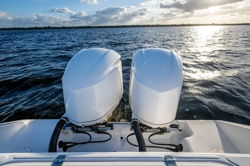 Slide: The Image of Twin outboard motors on a 2005 Jupiter 27 boat, cruising on a sunny day. - 28