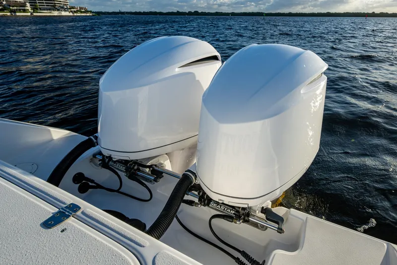 Slide: The Image of Twin outboard engines on a 2005 Jupiter 27 boat, cruising on a sunny day. - 29