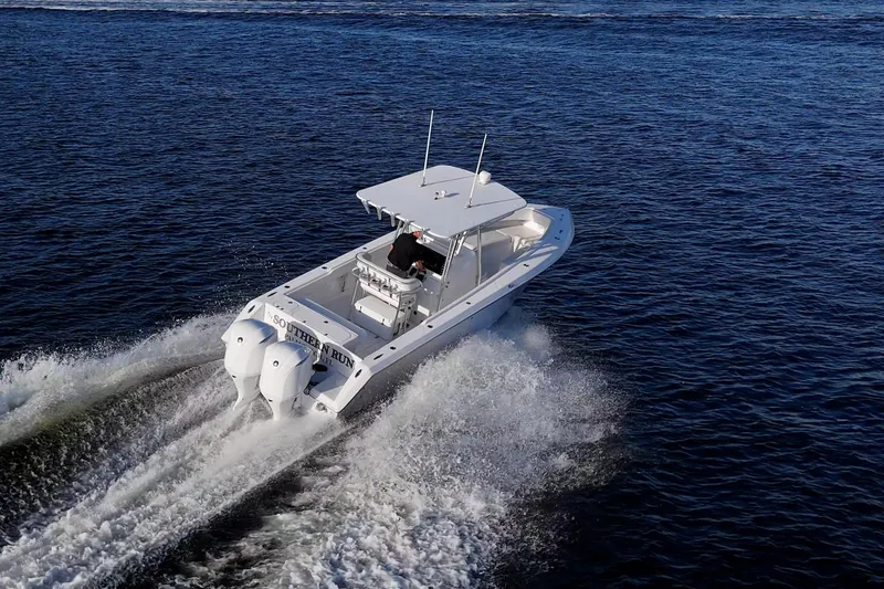 Slide: The Image of A 2005 Jupiter 27 boat cruising on open water, creating a wake. - 3