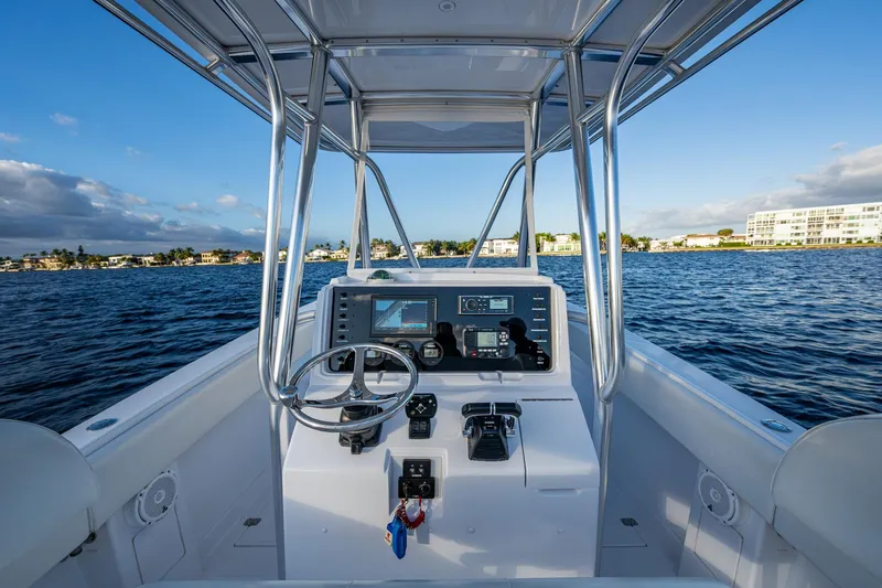 Slide: The Image of Center console of a 2005 Jupiter 27 boat on calm waters, clear sky background. - 34