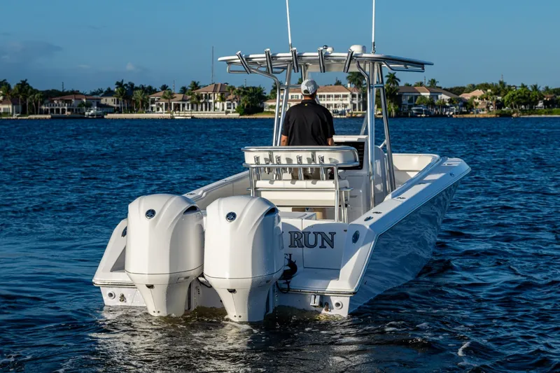 Slide: The Image of Jupiter 27 boat from 2005 on water, featuring dual engines and a center console. - 40