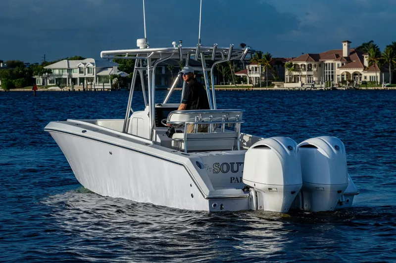 Slide: The Image of A 2005 Jupiter 27 boat with dual engines cruising on a scenic waterfront. - 48