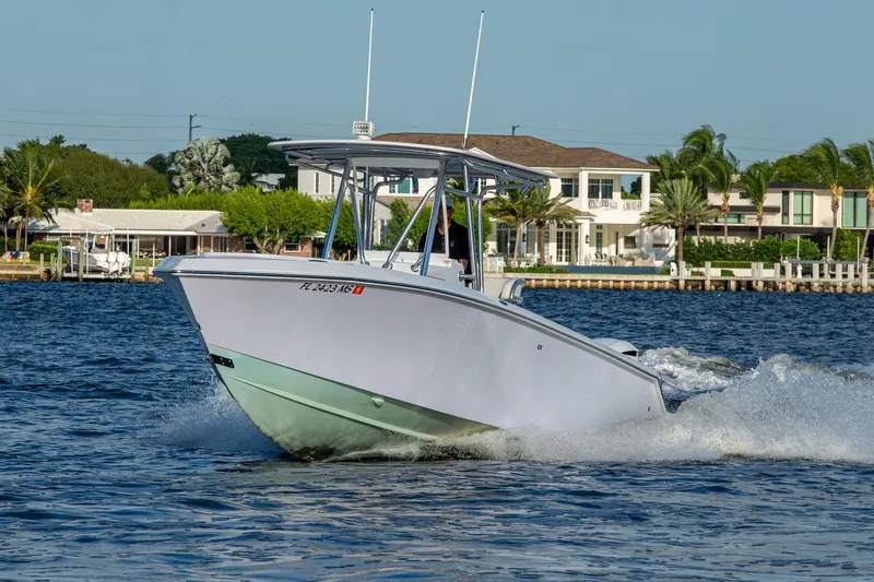 Slide: The Image of 2005 Jupiter 27 boat cruising on water near waterfront homes. - 49