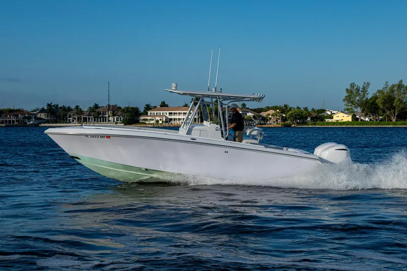 Slide: The Image of 2005 Jupiter 27 boat cruising on a sunny day near waterfront homes. - 50
