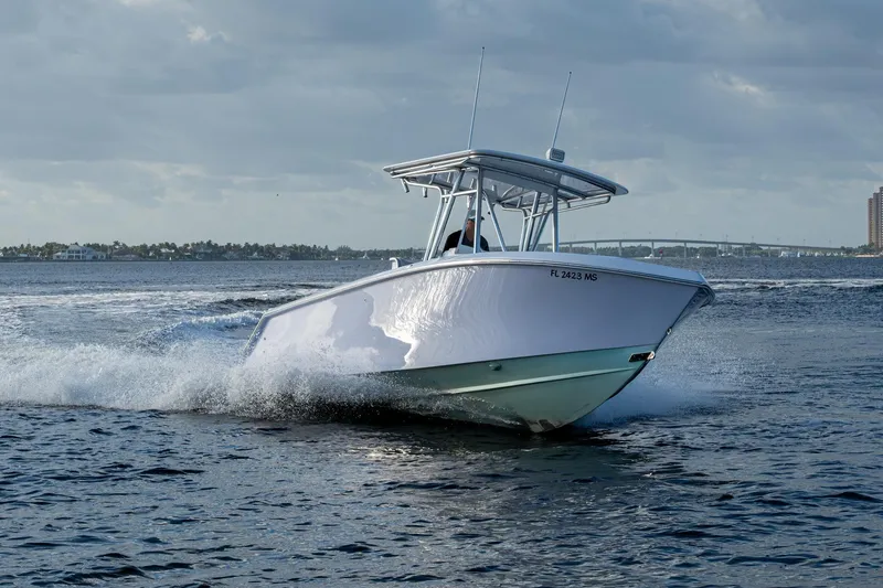 Slide: The Image of A 2005 Jupiter 27 boat cruising on open water under a cloudy sky. - 53