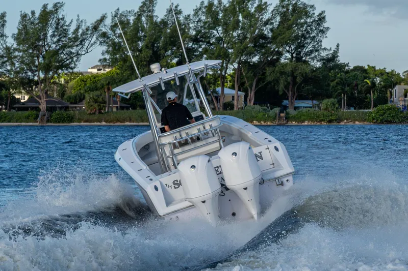 Slide: The Image of A 2005 Jupiter 27 boat cruising on a scenic waterway with lush greenery. - 57
