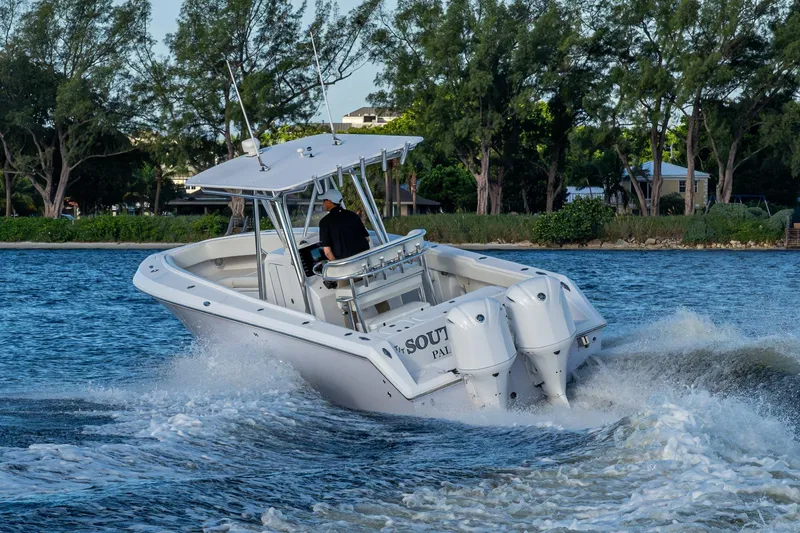 Slide: The Image of A 2005 Jupiter 27 boat cruising on a scenic waterway with lush greenery. - 58