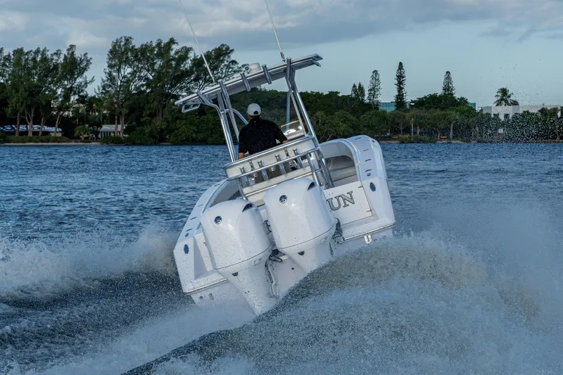 Slide: The Image of Boat navigating waters, Jupiter 27 model, 2005, creating waves under a cloudy sky. - 64