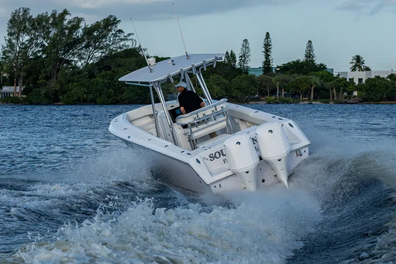 Slide: The Image of A 2005 Jupiter 27 boat cruising on a scenic waterway with lush greenery. - 65