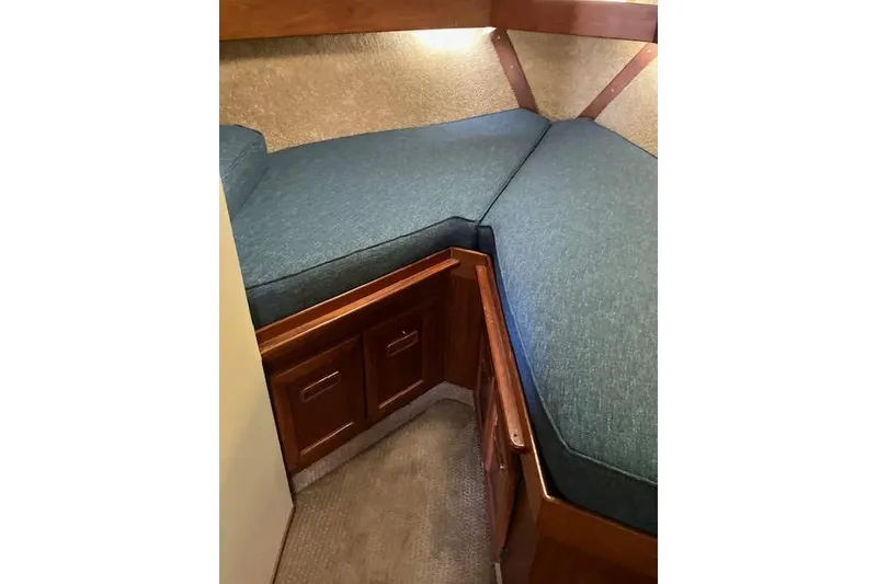 Slide: The Image of 1979 Pacemaker 40 Sportfisher cabin interior with blue cushions and wooden storage cabinets. - 14