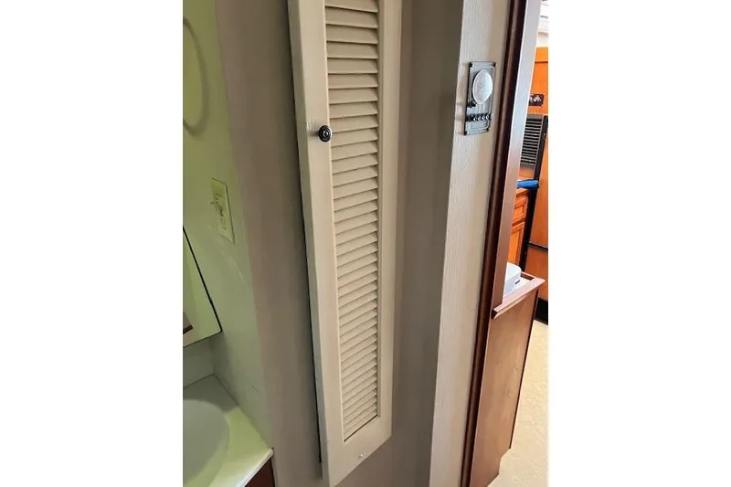 Slide: The Image of Interior view of a 1979 Pacemaker 40 Sportfisher, featuring a louvered door and thermostat. - 16