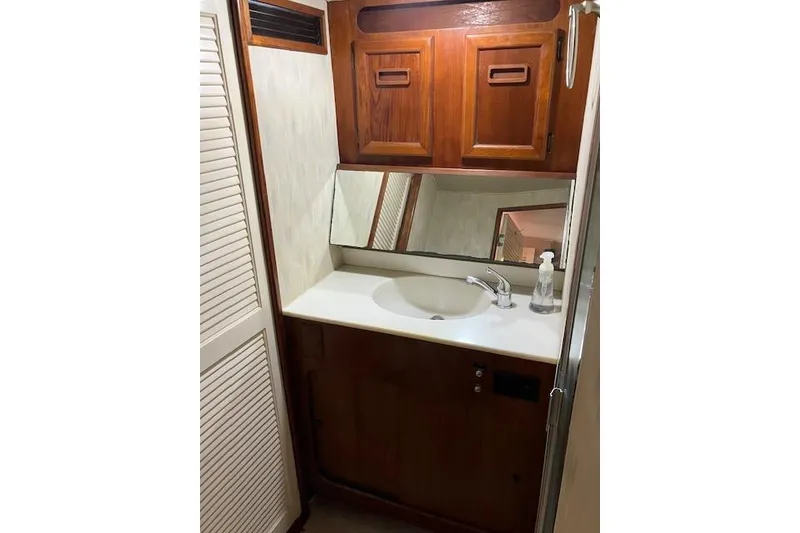 Slide: The Image of 1979 Pacemaker 40 Sportfisher bathroom with wooden cabinets and a white sink. - 17