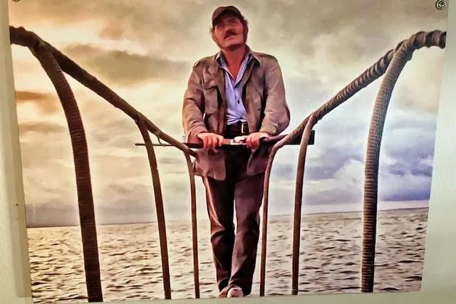 Slide: The Image of Man standing on a 1979 Pacemaker 40 Sportfisher boat, with ocean and cloudy sky backdrop. - 21