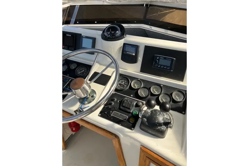 Slide: The Image of 1979 Pacemaker 40 Sportfisher helm with steering wheel, gauges, and navigation controls. - 26