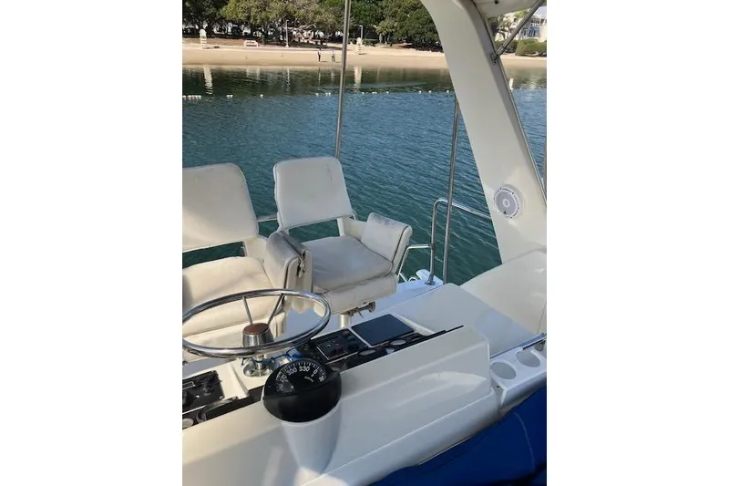 Slide: The Image of 1979 Pacemaker 40 Sportfisher boat interior with steering wheel and seating by the water. - 31