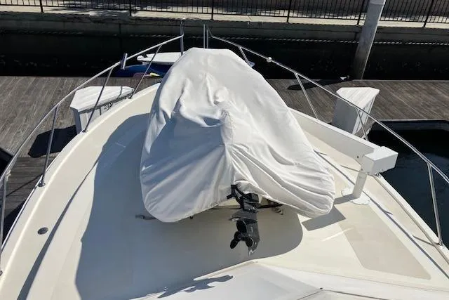 Slide: The Image of 1979 Pacemaker 40 Sportfisher boat deck with covered equipment, docked at marina. - 32