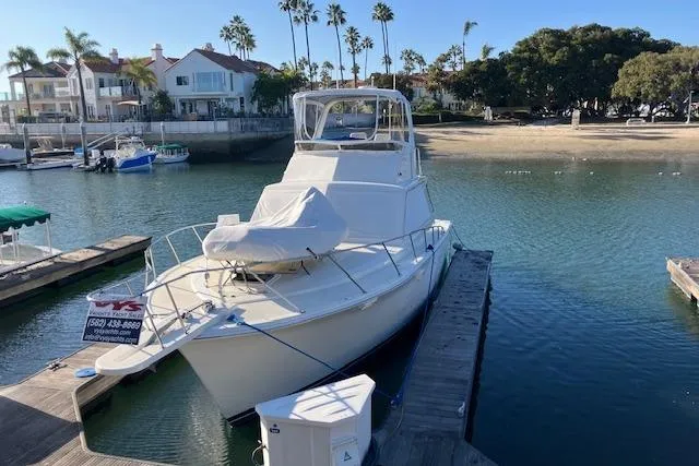 Slide: The Image of 1979 Pacemaker 40 Sportfisher docked in a scenic marina with palm trees. - 49