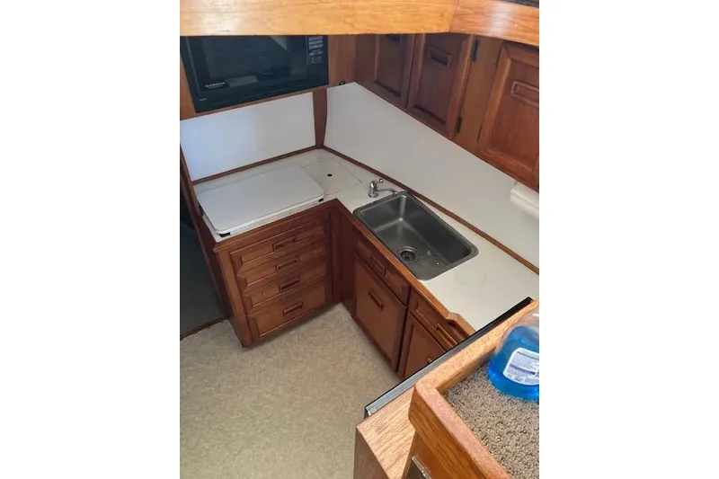 Slide: The Image of 1979 Pacemaker 40 Sportfisher kitchen with wooden cabinets, sink, and countertop. - 8