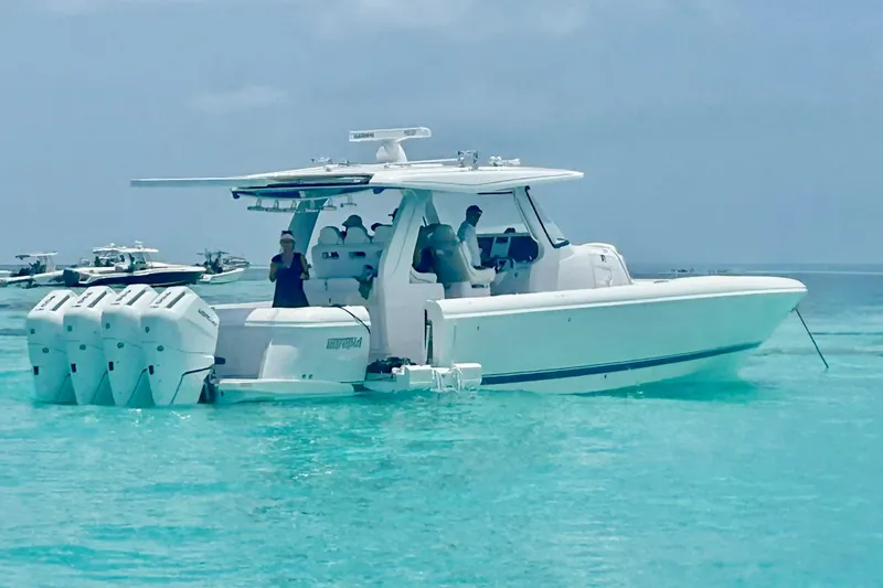 The Image of 2025 Intrepid 43 Nomad SE boat docked on a lift by waterfront property. - 1