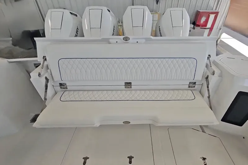 Slide: The Image of 2025 Intrepid 43 Nomad SE boat interior with white seating and Mercury engines. - 10