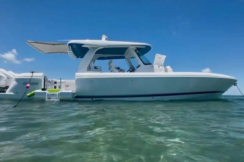 Slide: The Image of 2025 Intrepid 43 Nomad SE boat docked in a serene marina setting. - 2