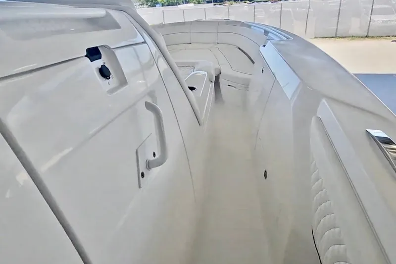 Slide: The Image of Interior view of 2025 Intrepid 43 Nomad SE boat with blue ceiling and white seating. - 37