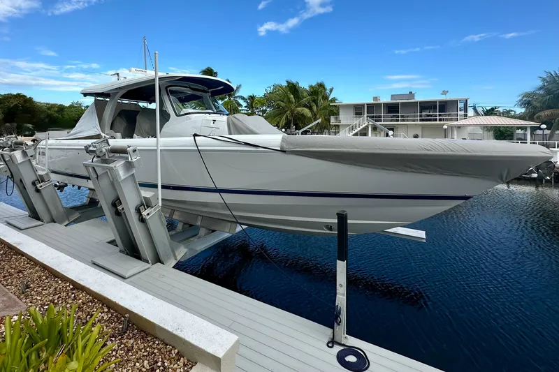 Slide: The Image of 2025 Intrepid 43 Nomad SE boat on clear turquoise water under cloudy sky. - 4