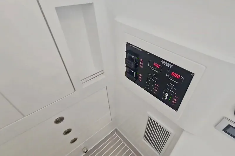 Slide: The Image of Interior of 2025 Intrepid 43 Nomad SE boat, featuring sleek white cabinetry and control panel. - 40