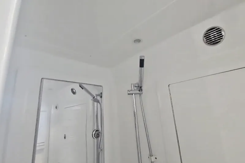 Slide: The Image of 2025 Intrepid 43 Nomad SE boat bathroom with white interior and compact toilet. - 43