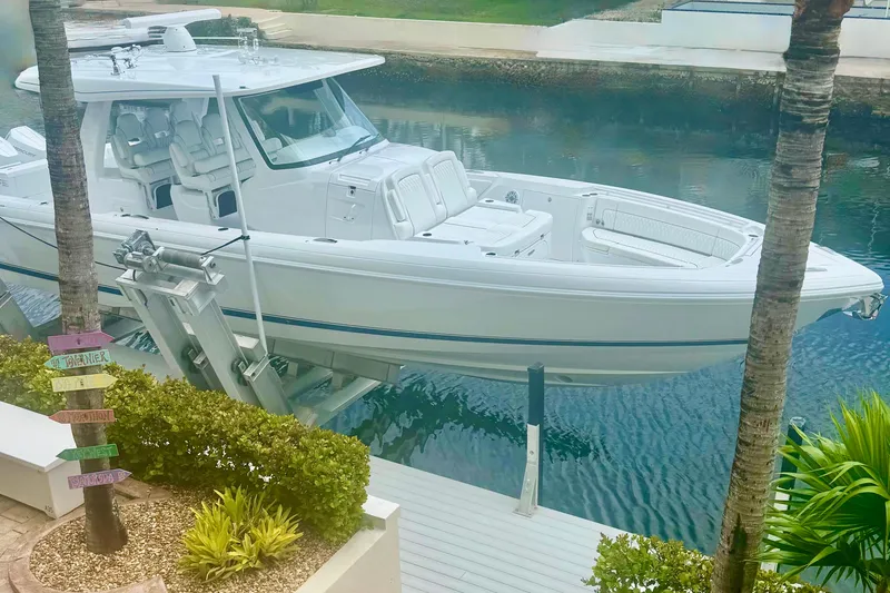 Slide: The Image of 2025 Intrepid 43 Nomad SE boat docked on a lift by waterfront property. - 78