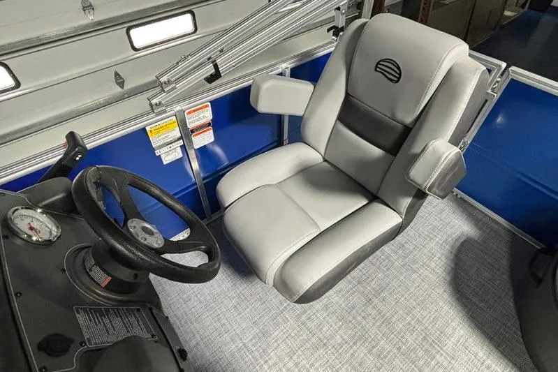 Slide: The Image of 2026 Sun Tracker Party Barge 16 DLX captain's chair and steering wheel interior. - 10