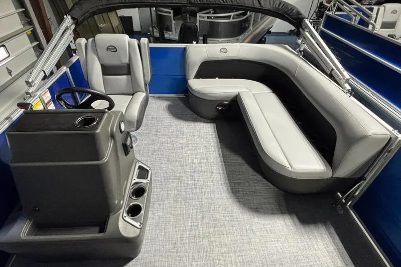 Slide: The Image of 2026 Sun Tracker Party Barge 16 DLX interior with gray seating and steering console. - 6