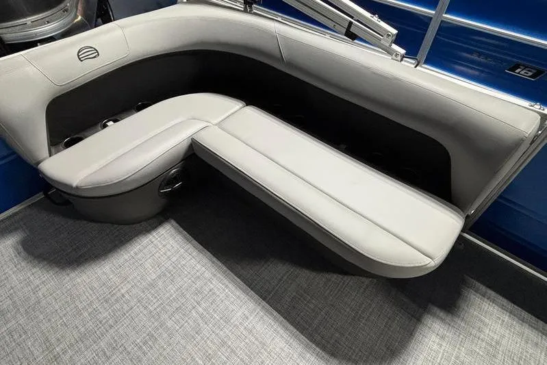 Slide: The Image of 2026 Sun Tracker Party Barge 16 DLX interior seating with gray upholstery and cup holders. - 7