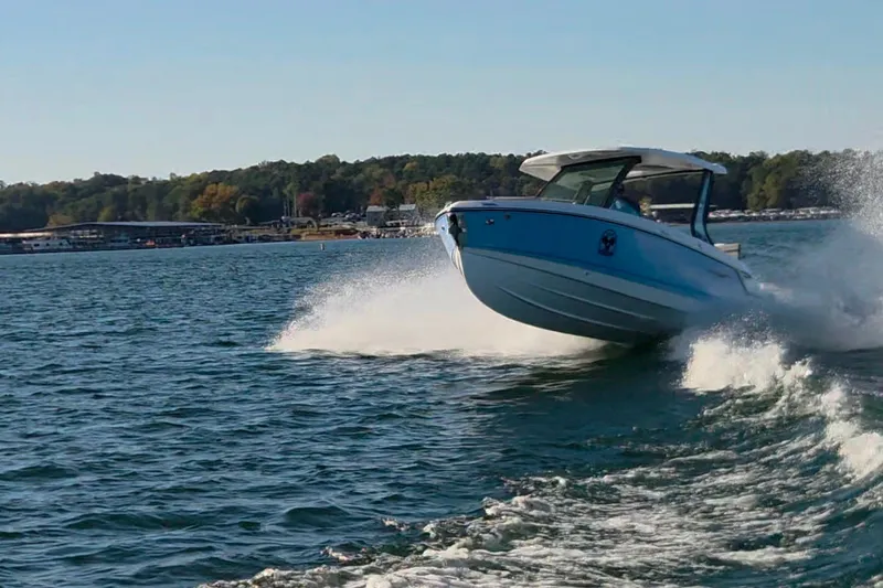 Slide: The Image of 2026 Monterey Elite 27 OB boat cruising on a lake, creating a dynamic water splash. - 6