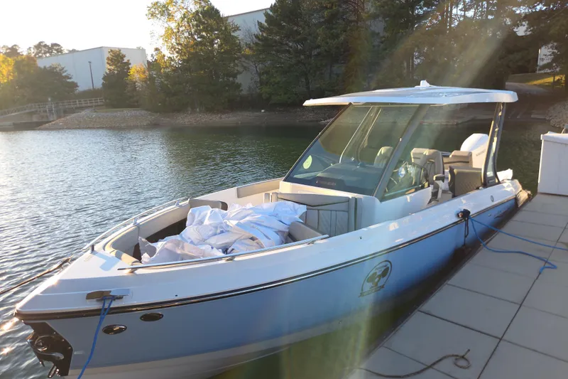 Slide: The Image of 2026 Monterey Elite 27 OB boat docked on a serene lake under sunlight. - 8