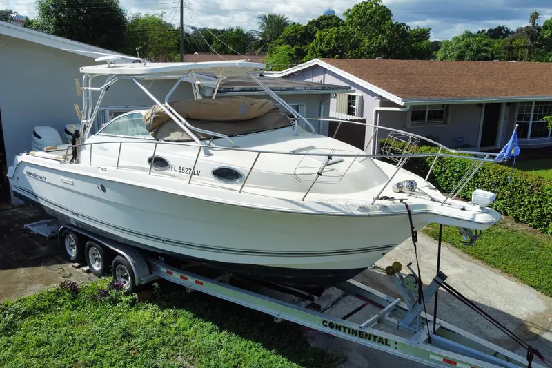Slide: The Image of 2002 Wellcraft 290 Coastal boat on trailer in residential driveway. - 10